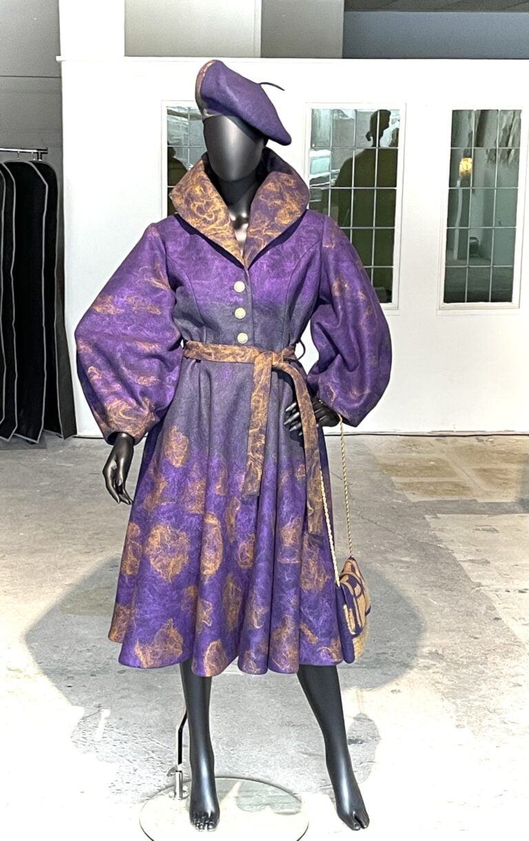 Prachtige robe in diep paarse kleur met gele details, ballon mouwen en sjaalkraag